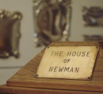 Wooden stand in foreground with Brass sign 'The House of Newman'