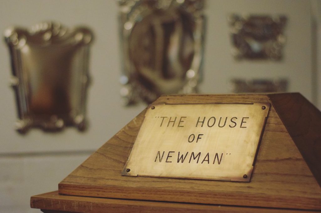 Wooden stand in foreground with Brass sign 'The House of Newman'