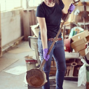 Sarah holding a large slightly rusty looking Casting ladle.