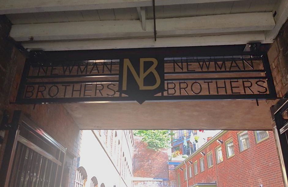 Coffin Works gates with Newman Brothers sign above entranceway in metal