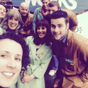 volunteers take a group selfie in front of a brick wall