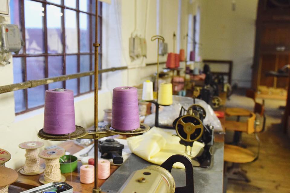 Sewing machines in the shroud room. Brightly coloured cotton reels can be seen in the foreground