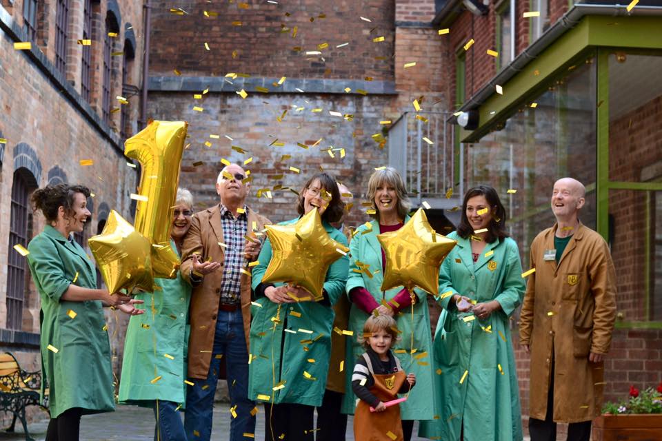 Celebration in the coffin works' courtyard with balloons and confetti in the air