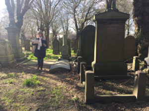 Mary standing in a cemetery on a sunny day