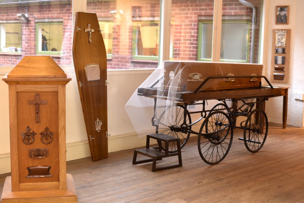 Coffin and coffin furniture on the first floor of the building.