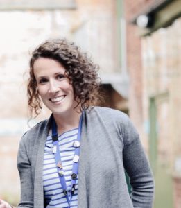 Sarah Hayes smiling, standing in Coffin Works courtyard.