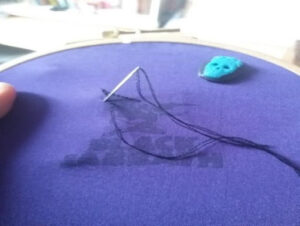 needle with thread in purple material