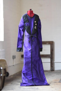 dark purple home of metal shroud with black accents mounted on dressmaker dummy