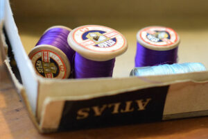 the reels of purple sewing thread in a box