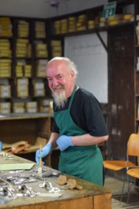 Francis cleaning an object in stock room