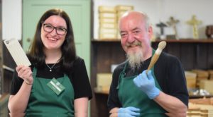 Francis and volunteer pose in stockroom