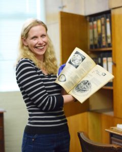 woman holding up an open cookery book