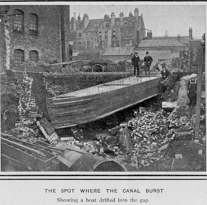 black and white newspaper image. two men stare down at a barge sitting in ruins