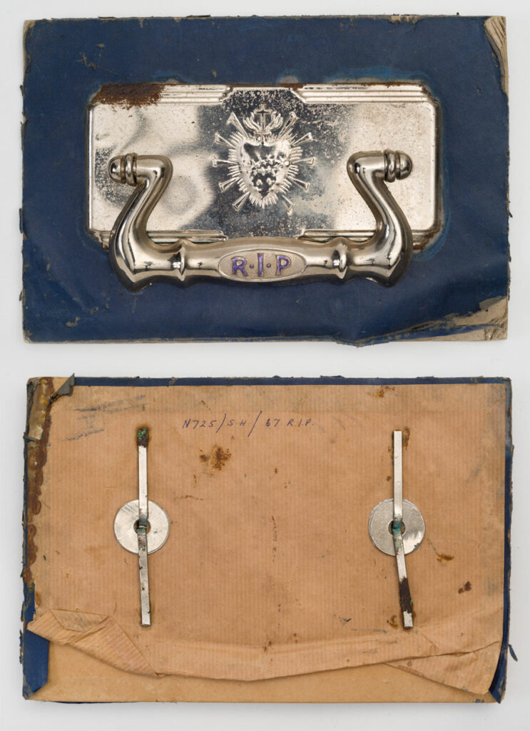 Front and reverse sides of a silver coloured handle affixed on blue card