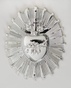 Nickel plated sacred heart ornament. A heart shape with crucifix on top, emitting a halo of rays