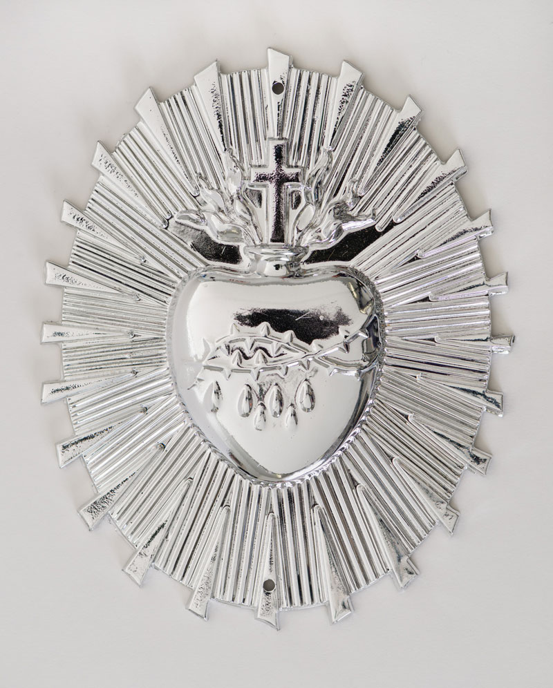 Nickel plated sacred heart ornament. A heart shape with crucifix on top, emitting a halo of rays