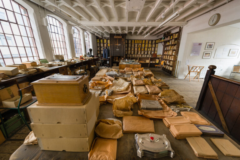 Warehouse, image dominated by packing table featuring packaged items and items ready for packaging