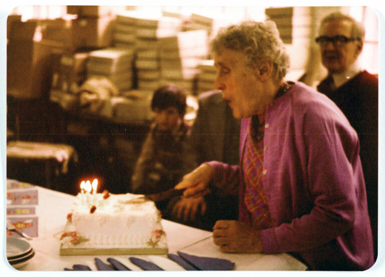Grainy image of Dolly Dunsby blowing out candles on her birthday cake