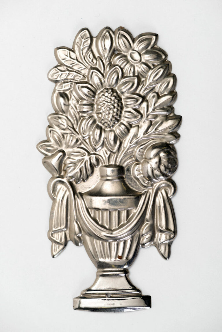 Tin silver coloured urn ornament with sunflower growing from the top