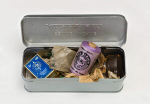 Open Sewing tin featuring purple sewing thread and other items
