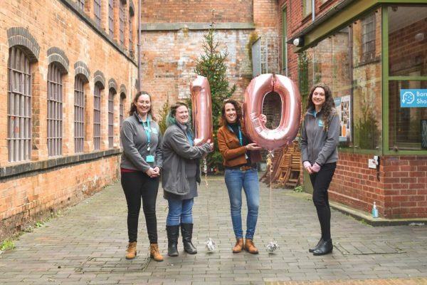 Group of women holding balloons that depict number 10.