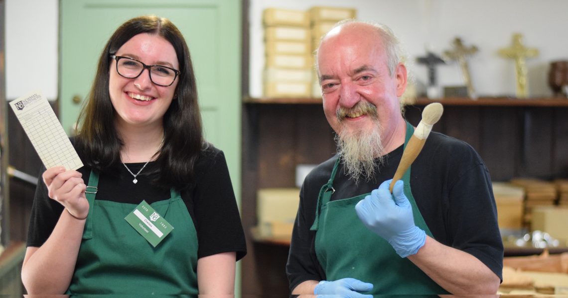 Francis and volunteer pose in stockroom