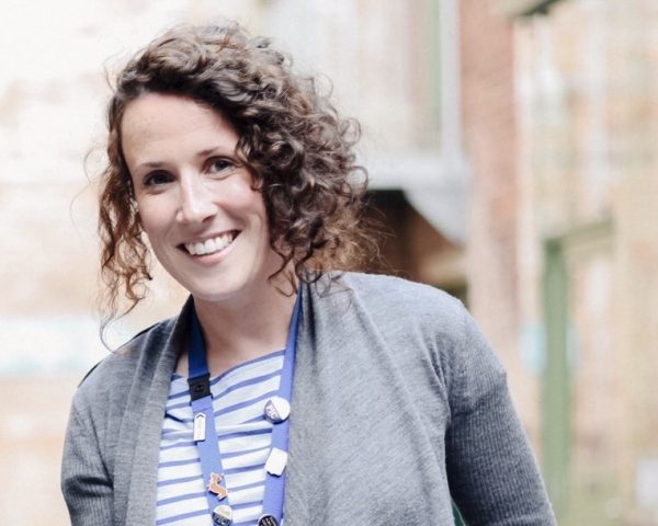 Sarah Hayes smiling, standing in Coffin Works courtyard.