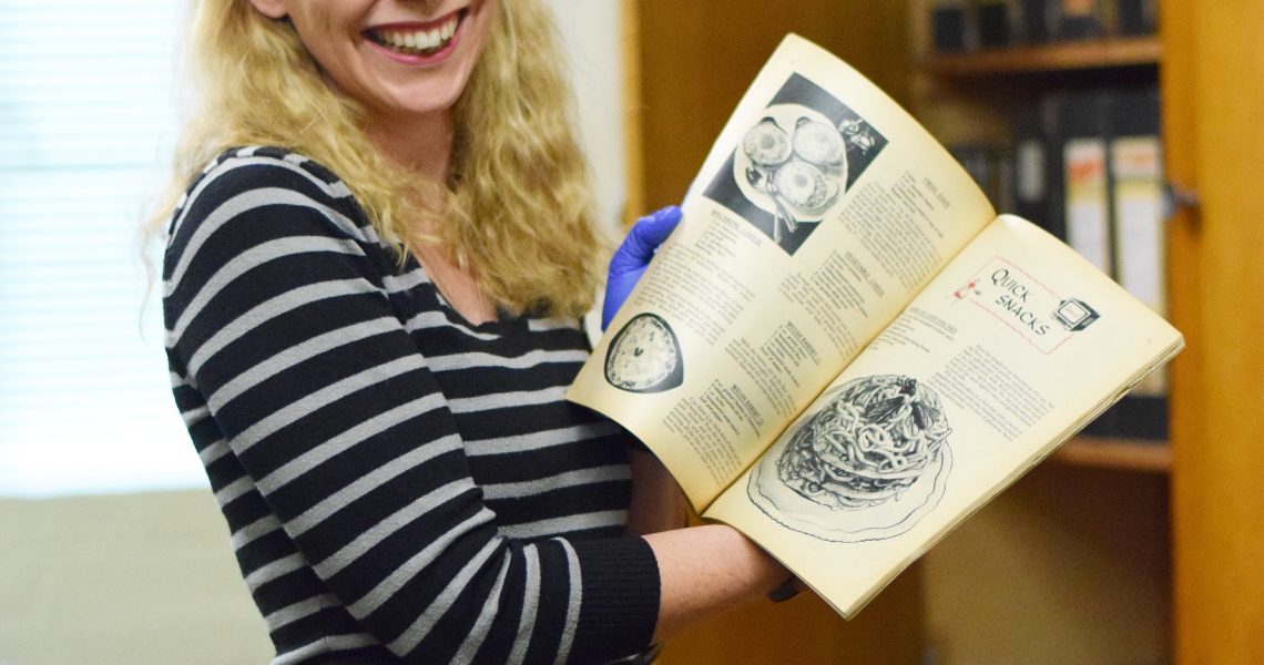 woman holding up an open cookery book