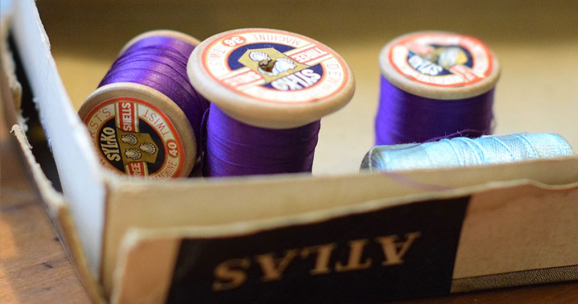 the reels of purple sewing thread in a box